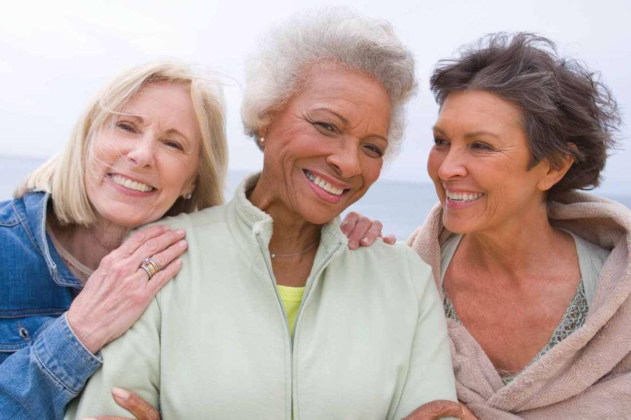 Three woman huddled together and smiling